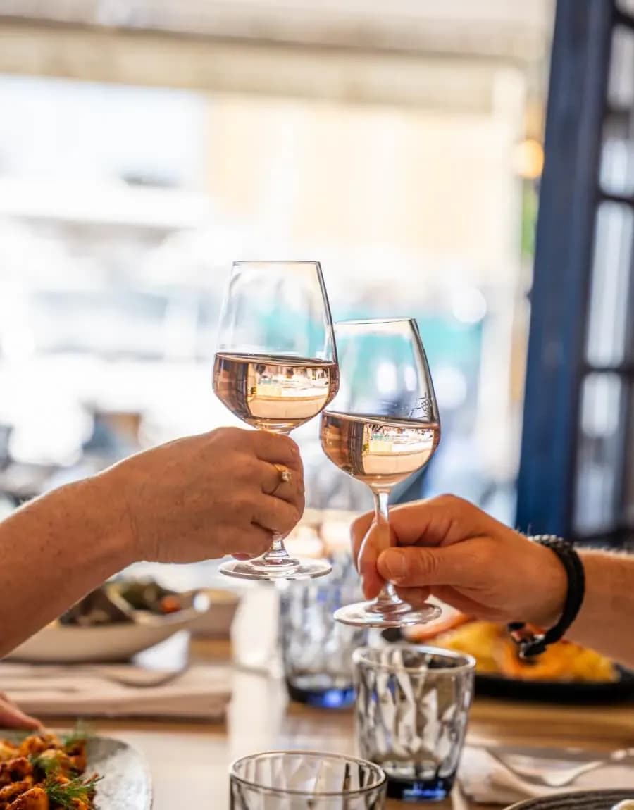 Deux convives trinquent avec des verres de vin rosé lors d'un repas au restaurant La Marée, près de Sainte-Maxime